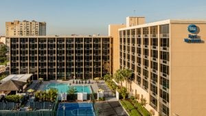 hotel exterior with pool and basketball court